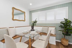 a dining room with a glass table and chairs at Unit 6 Nirvana in Yaroomba