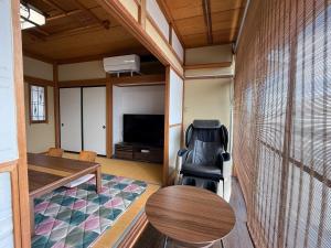 ein Zimmer mit einem Schreibtisch, einem Stuhl und einem Tisch in der Unterkunft かんさんのお宿 in Fuji