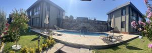 a house with a swimming pool in the yard at Baska Urla Otel in Denizli