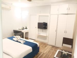 a bedroom with a bed and a desk and a tv at Hotel Chandigarh Elite in Chandīgarh