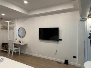 a living room with a tv on a white wall at Bangkok Sleep Nest in Sathani Ban Hua Mak