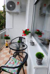 a balcony with a table and chairs and flowers at Jucus Apartman in Makó +6 photos