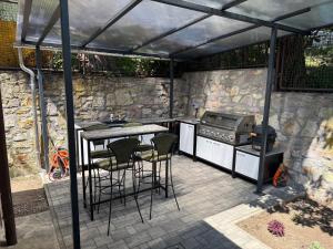 a patio with a grill and a table and chairs at Kozmáry Vendégház in Matrafured