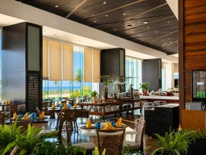 a restaurant with tables and chairs in a lobby at Arterra Hotel and Resort in Mactan