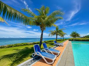 a row of beach chairs next to a swimming pool at Arterra Hotel and Resort in Mactan
