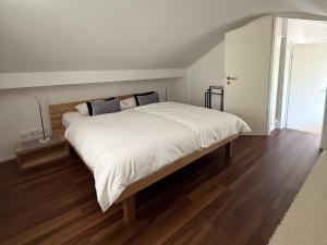 a bedroom with a large bed with white sheets at Haus am Bach in Roitham
