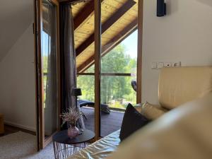 a living room with a couch and a glass door at Haus am Bach in Roitham