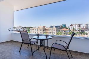 a table and chairs on a balcony with a view at Bright Stylish Flat With Balcony & Shared Pool in Scala