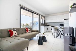 a living room with a couch and a table at Bright Stylish Flat With Balcony & Shared Pool in Scala