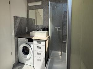 a bathroom with a washing machine and a sink at Haus am Bach in Roitham +15 photos