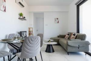 a living room with a couch and a table at Bright Stylish Flat With Balcony & Shared Pool in Scala +4 photos