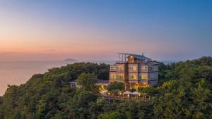 a large house on top of a hill next to the ocean at Yeongheungdo noeul&bada pension in Incheon