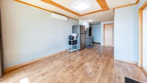 an empty living room with wooden floors and a ceiling at Yeongheungdo noeul&bada pension in Incheon +14 photos