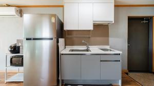 a kitchen with a stainless steel refrigerator and a sink at Yeongheungdo noeul&bada pension in Incheon
