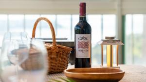 a bottle of wine and a basket on a table at Yeongheungdo noeul&bada pension in Incheon