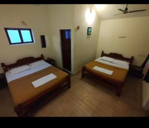 a bedroom with two beds and a window at Wildfarms resort in Masinagudi
