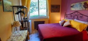 a bedroom with a red bed and a window at At Armando's Home in Zafferana Etnea