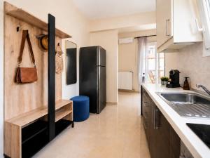 a kitchen with a black refrigerator and a sink at KRAKEN Apartment in Leptokarya