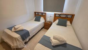 two beds in a small room with two pillows at Vistamar -primera linea de playa in El Borseral