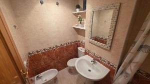 a bathroom with a sink and a toilet and a mirror at Vistamar -primera linea de playa in El Borseral +28 photos