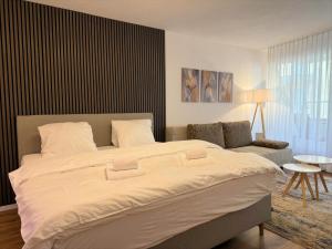 a bedroom with a large bed and a couch at Lorez 5A by Arosa Holiday in Arosa +4 photos
