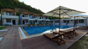 a pool with benches and umbrellas on a wooden deck at Arsuz Suite House in Arsuz