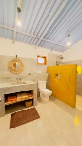a bathroom with a toilet and a sink at Richards Cabanas in Tissamaharama