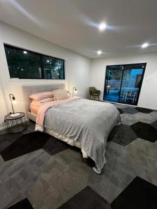 a bedroom with a large bed and two windows at 2 Bedroom Comfortable Guest Wing in Hamilton