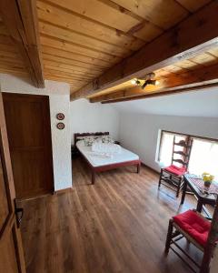 a room with a bed and a table and chairs at Pensiunea Cambiano in Beliş