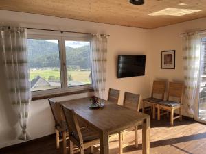 a dining room with a table and chairs and a large window at Appartements Dürnle in Mühldorf