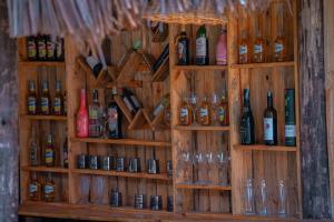 a wall with shelves filled with bottles and glasses at Hakuna matata villas & hostels in Arusha +24 photos