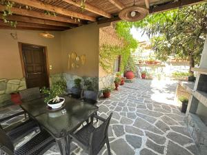 a patio with a table and chairs on a patio at THEODORAS HOUSE in Iraklitsa