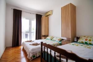 a bedroom with two beds and a window at Apartments Stevo Nikočević in Bar