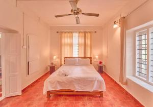 a bedroom with a bed and a ceiling fan at Ministers Mansion Kanthalloor Pool Resort by VOYE HOMES in Kanthalloor +40 photos