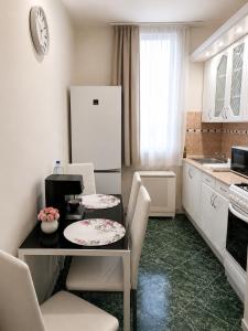 a kitchen with a table with chairs and a refrigerator at Jucus Apartman in Makó