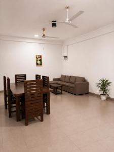 a living room with a couch and a table and chairs at Prabha Garden Boutique Villa in Anuradhapura