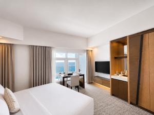 a hotel room with a bed and a dining room at Arterra Hotel and Resort in Mactan