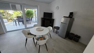 a living room with a table and chairs and a refrigerator at Apartments Peace&Love in Baška