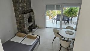 a living room with a stone fireplace and a table and chairs at Apartments Peace&Love in Baška