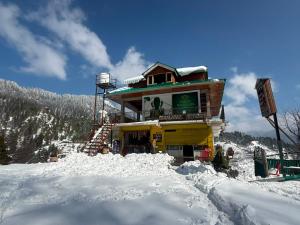 a building on top of a snow covered mountain at Himalyan Kitchen & Stay in Matiāna