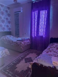 a bedroom with two beds and a window with purple lighting at Guest hous Tamuna in Martvili