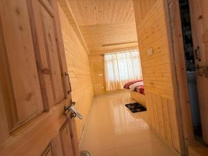 a hallway in a wooden house with a door at Himalyan Kitchen & Stay in Matiāna