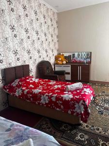 a bedroom with a bed with a red blanket and a chair at Guest hous Tamuna in Martvili