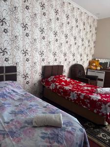 a bedroom with two beds and floral wallpaper at Guest hous Tamuna in Martvili
