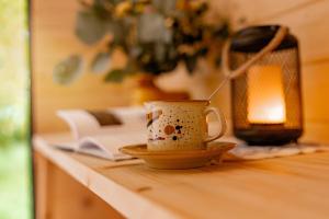a coffee cup on a table with a spoon in it at Maringotka Vojenského Stylu na Šumavě in Bošice