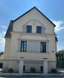 a white house with a black fence at Apartment Hafingervilla in Sankt Pölten