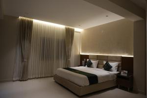 a bedroom with a large bed and a window at Galaxy Air Suites in Bangalore +9 photos