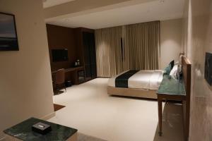 a hotel room with a bed and a desk at Galaxy Air Suites in Bangalore