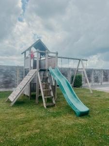 a playground with a slide in the grass at B&B El Bayo in Ravels
