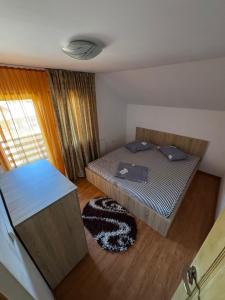 a small bedroom with a bed and a window at Cabana LUCI - FIGA in Beclean +9 photos